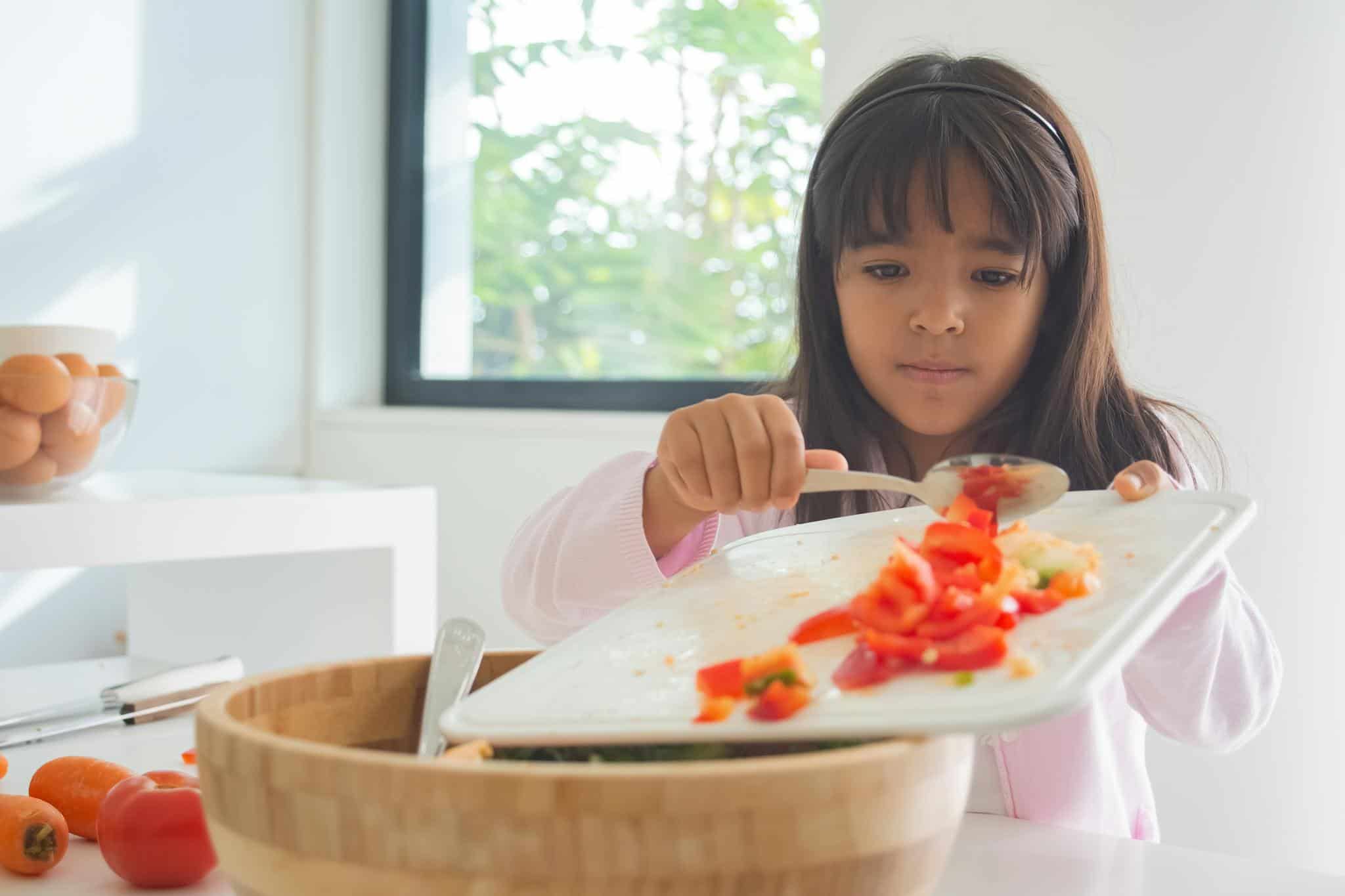 Girl Holding Chopping Board with Sliced Tomatoes